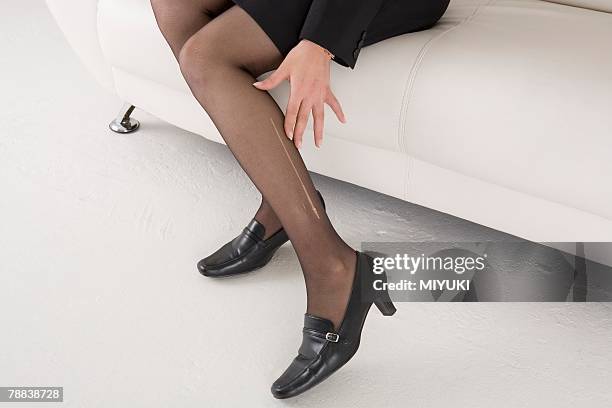 young woman with laddered stockings - nylon stock pictures, royalty-free photos & images