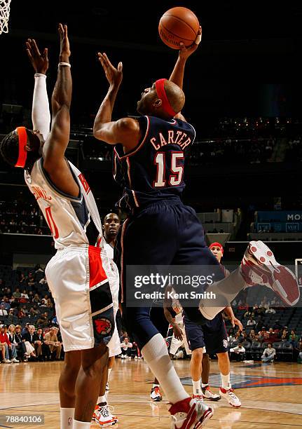 Vince Carter of the New Jersey Nets shoots against Jeff McInnis of the Charlotte Bobcats on January 8, 2008 at the Charlotte Bobcats Arena in...