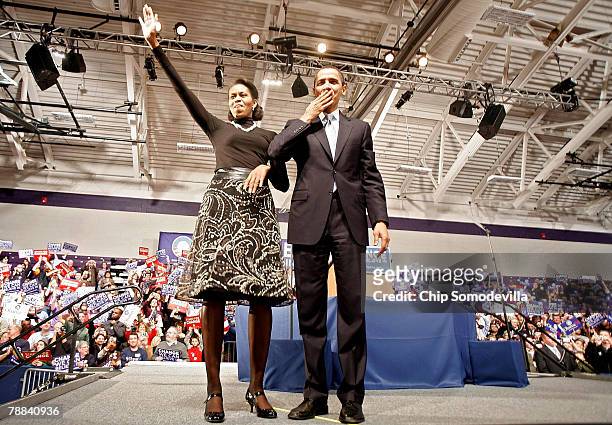 Democratic presidential hopeful Sen. Barack Obama and his wife Michelle Obama take the stage at a primary night rally in the gymnasium at the Nashua...