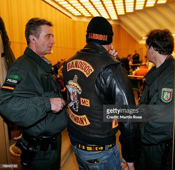 Policemen surround a member of the biker group 'Bandidos' outside the district court on January 9,2008 in Muenster, Germany. The two biker groups at...