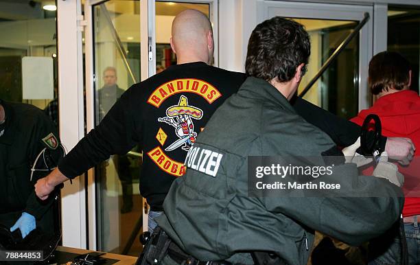 Policeman checks a member of the biker group 'Bandidos' outside the district court on January 9, 2008 in Muenster, Germany. The two biker groups at...