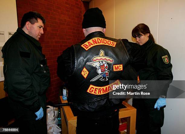 Policemen surround a member of the biker group 'Bandidos' outside the district court on January 9,2008 in Muenster, Germany. The two biker groups at...