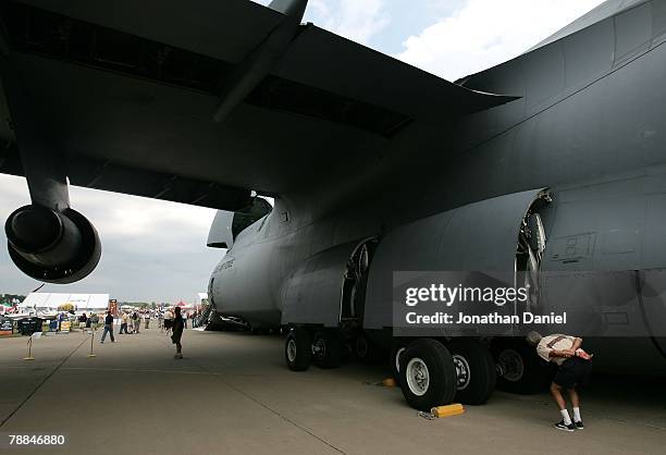 An airplane enthusiast looks into the wheel well of a C-5 Galaxy, one of the largest military aircraft in the world, during the Experimental Aircraft...