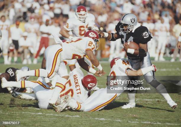 Bo Jackson, Full Back for the Los Angeles Raiders is tackled by Jeff Donaldson, Kevin Porter and Dino Hackett for the Kansas City Chiefs during their...