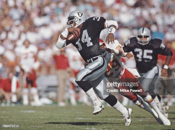 Bo Jackson, Full Back for the Los Angeles Raiders dodges a tackle attempt by Albert Lewis, defensive back for the Kansas City Chiefs during their...