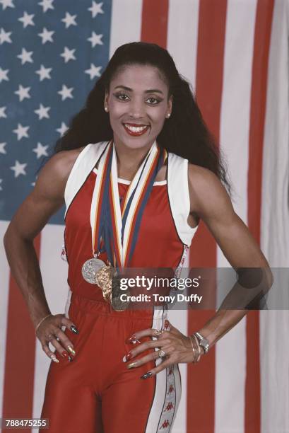 Florence Griffith-Joyner poses for a portrait in front of the Stars and Stripes flag of theUnited States with her medals for winning gold in the...