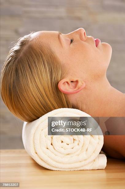 young woman with closed eyes lying on a towel roll - b roll stock pictures, royalty-free photos & images