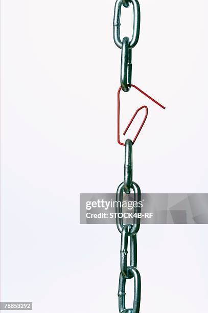 paper clip between chain links - a chain is as strong as its weakest link foto e immagini stock