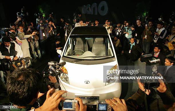 Mediapersons photaograph the newly unveiled Tata "Nano" car at the launch in New Delhi, 10 January 2008. India's giant Tata Group unveiled a USD...