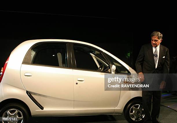 Chairman of India's giant Tata Group Ratan Tata poses in front of the Tata "Nano" car during the launch in New Delhi, 10 January 2008. India's giant...