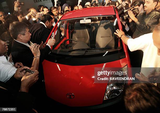 People crowd around the Tata "Nano" car during the launch in New Delhi, 10 January 2008. India's giant Tata Group unveiled a USD 2,500 car it bills...