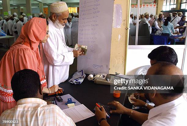 Visiting members of an Islamic Shia gathering of the Bohra community exchange money in Sri Lanka's capital Colombo, 11 January 2008. Some 30,000...