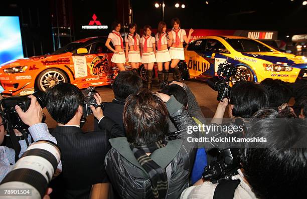 Amateur photographers takes pictures while Mitsubishi Motors' racing queens pose during the 26th Tokyo Auto Salon at Makuhari Messe on January 11,...