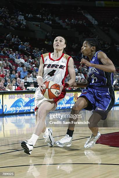 Tully Bevilaqua of the Portland Fire drives past Kedra Holland-Corn of the Sacramento Monarchs during the WNBA game at the Rose Garden in Portland,...