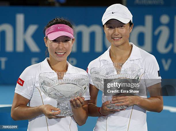 Jie Zheng and Zi Yan of China hold their trophies after beating Tatiana Perebiynis of the Ukraine and Tatiana Poutchek of Belarus in the women's...