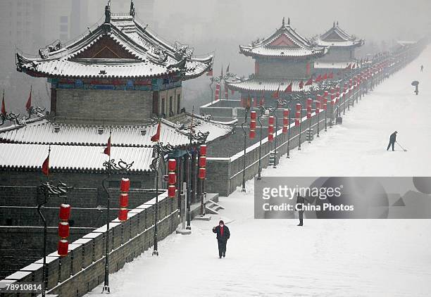 Pedestrians walk along the South Gate of Xian City Wall after a snowfall on January 12, 2008 in Xian of Shaanxi Province, China. Heavy snow struck...