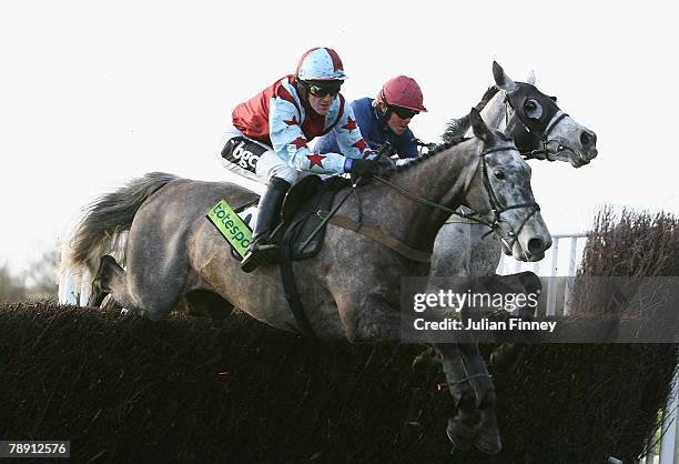 Arnold Layne ridden by Tony McCoy and D'Argent ridden by Robert Thornton jump a fence on the first lap of The totesport.com Classic Steeple Chase run...