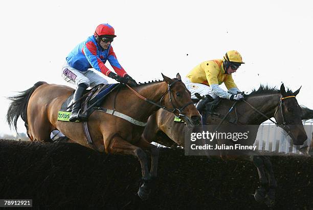 Kilbeggan Blade ridden by Paddy Brennan and Philson Run ridden by Daryl Jacob jump a fence in The totesport.com Classic Steeple Chase run during...