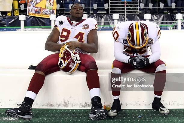 Defensive tackle Anthony Montgomery and safety LaRon Landry of the Washington Redskins sit on the bench after the Seattle Seahawks defeated the...