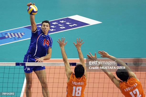 Ivan Miljkovis of Serbia smashes the ball against the block of Jeroen Paul Trommel and Wytze Koolstr of Netherlands during a semi-final of the...