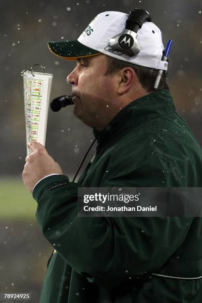 Head coach Mike McCarthy of the Green Bay Packers holds his playbook in front of his face from the sideline against the Seattle Seahawks during the...