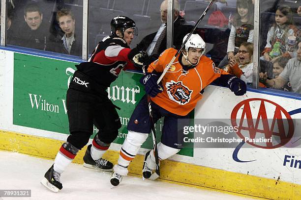 Bridgeport, CT Right wing Pierre Luc-Faubert of the Bridgeport Sound Tigers is checked by defenseman Brett Festerling of the Portland Pirates during...