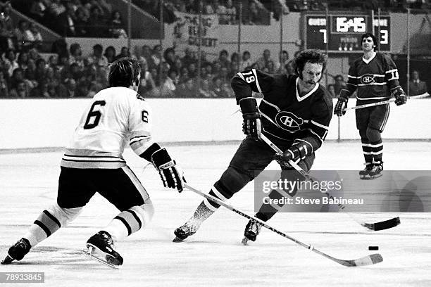 Larry Robinson of the Montreal Canadiens carries the puck in the offensive zone against Daryl Edestrand of the Boston Bruins.