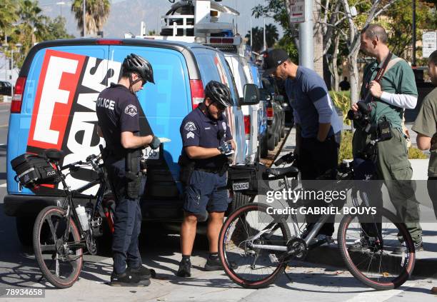 Police officers give a ticket 14 January 2008 to media members who were chasing the car of Mark Vincent Kaplan, attorney for Britney Spears'...