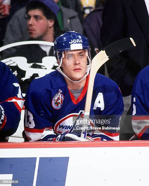 Teemu Selanne of the Winnipeg Jets watches action from bench in game against the Boston Bruins .