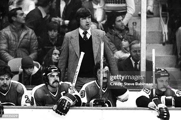 Pat Quinn coach of the Philadelphia Flyers plays behind bench, against the Boston Bruins .
