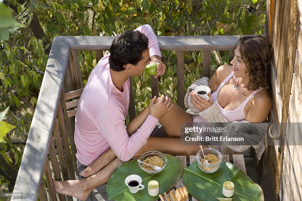 Couple eating breakfast outdoors.