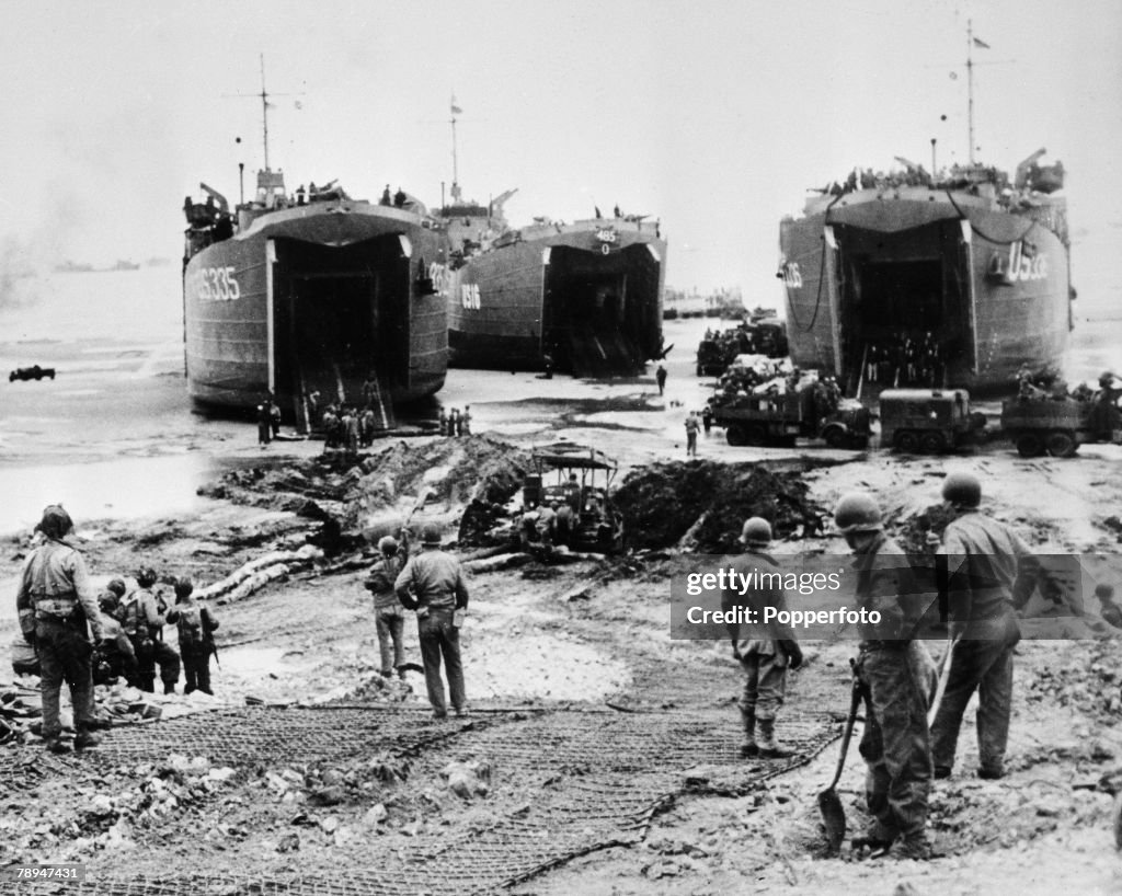 War & Conflict. World War Two. France 6th June 1944. Allied infantry army units unload supplies (including tanks and trucks) from large landing craft onto the Normandy beaches during the D Day invasion.