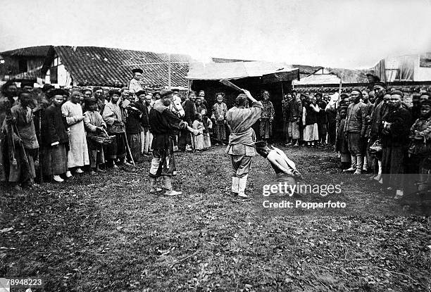 Volume 2, Page 123, Picture 4, A man is on his knees, about to be executed by be-heading, in front of a large crowd, during the Boxer rebellion China