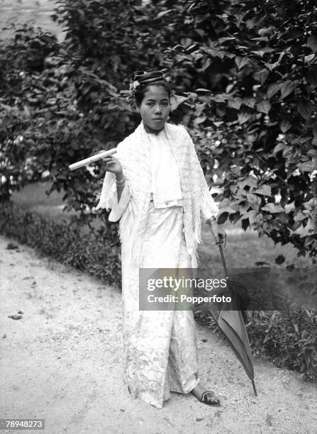 Ponting in Asia 1900 - 1906, Burma, A native Burmese girl wearing traditional dress holding a cheroot