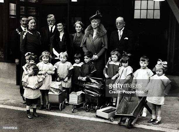 22nd October 1937, HM,Queen Mary, pictured with Lady Astor with children, during the visit to the Rachel MacMillan College at Deptford, London, Queen...