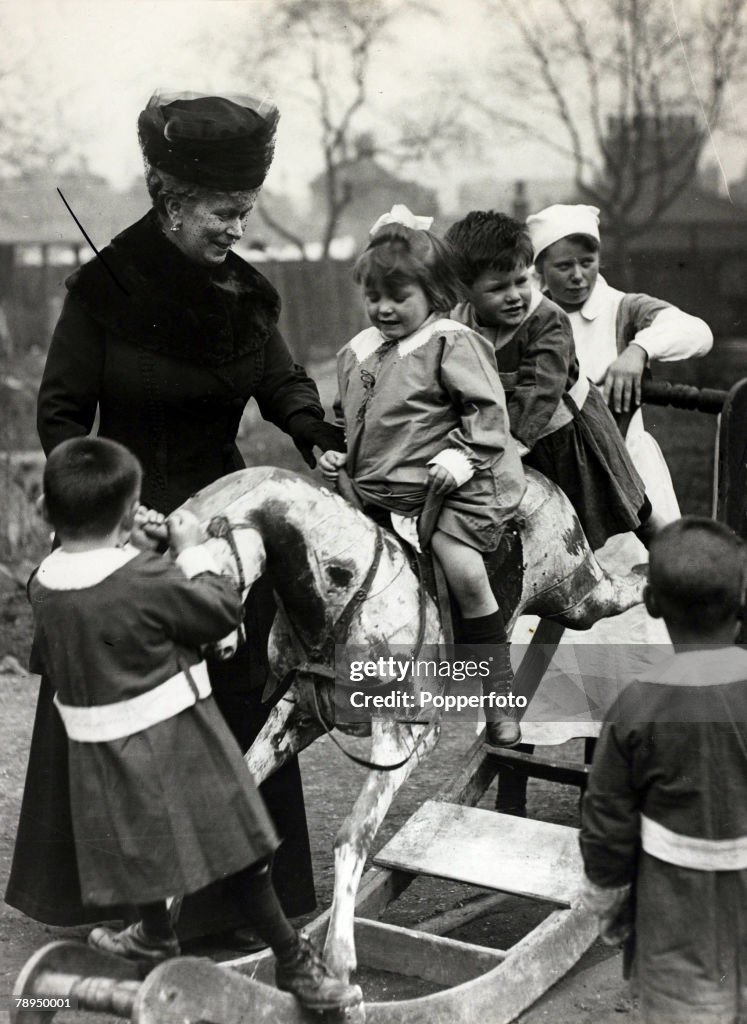 History Personalities. British Royalty. pic: 1919. HM.Queen Mary pictured in this happy picture at Deptford, London, at a day nursery, with children on a rocking horse. Queen Mary (1867-1953) born Mary of Teck, became Queen Consort when her husband King G