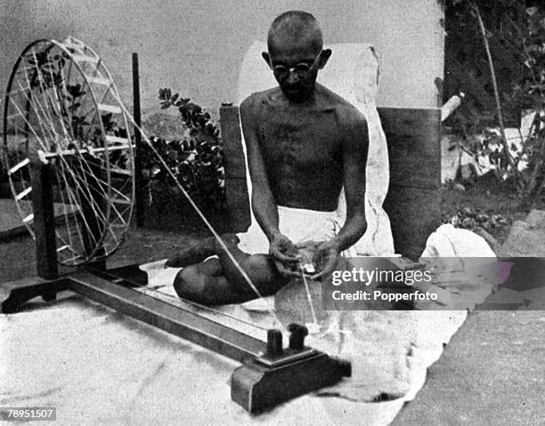 Picture of Mahatma Gandhi , the Indian political and spiritual leader, guru and social reformer , at his spinning wheel