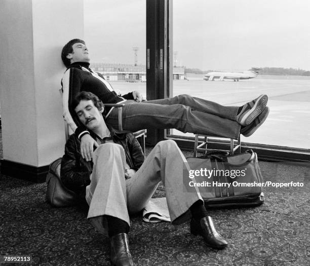 Liverpool footballers Terry McDermott and Emlyn Hughes sleeping at an airport as they wait for their flight, circa 1978.