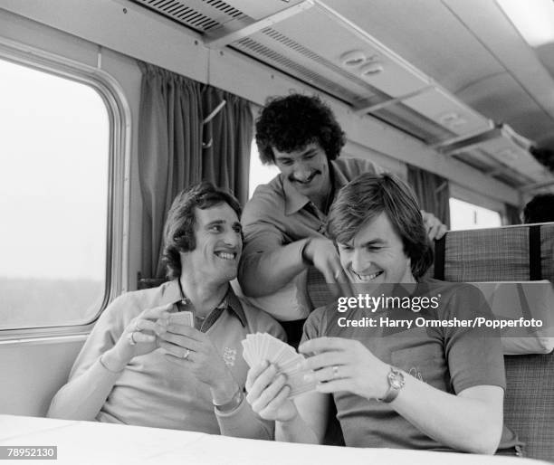 Liverpool footballers Ray Clemence and Kenny Dalglish are joined by Terry McDermott as they relax by playing cards on the train before their FA Cup...