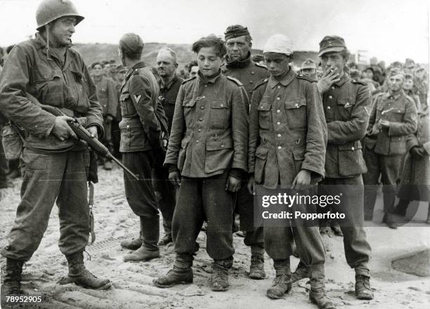 War and Conflict, World War Two, Western Front, pic: June 1944, Two young German soldiers, perhaps as young as 15, lead a group of prisoners captured...