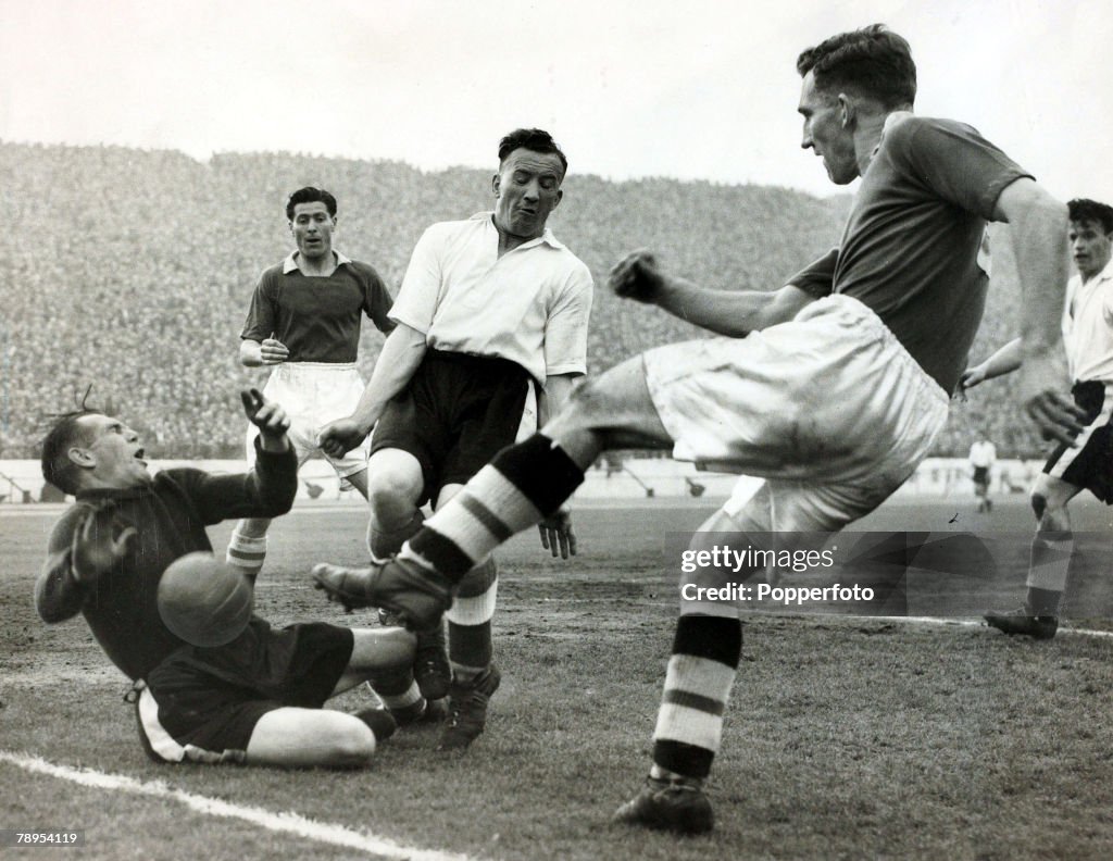 Sport. Football. pic: 23rd April 1955. Division 1. Chelsea 3. v Sheffield Wednesday 0. at Stamford Bridge. Chelsea centre forward Roy Bentley shoots for goal as Sheffield Wednesday goalkeeper Dave McIntosh dives in an attempt to block, which led to him be