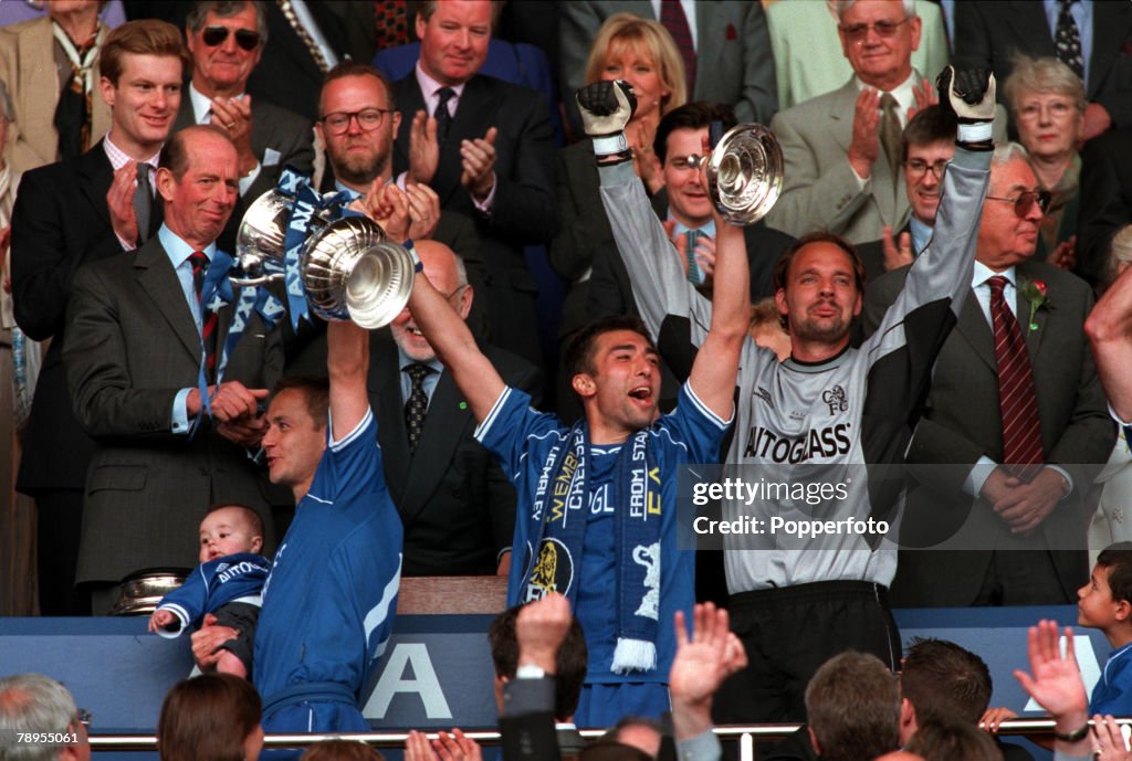 20th May 2000. Wembley, London. AXA FA Cup Final. Chelsea 1 v Aston Villa 0. Chelsea captain Dennis Wise receives the Cup with his baby son Henry, scorer Roberto Di Matteo centre, Ed De Goey, right.