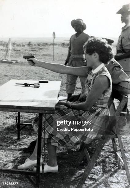 People, Terrorism, Africa, pic: circa 1952, near Nairobi, Kenya, A white housewife is given instruction on how to use a handgun to protect herself,...