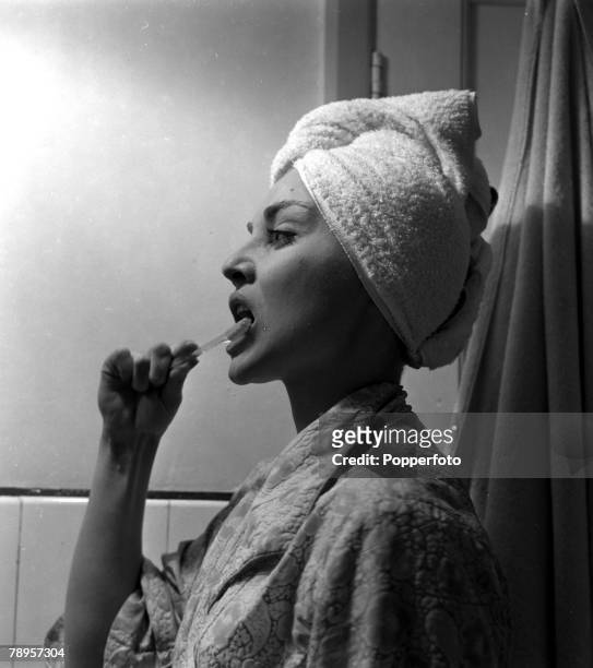 England British actress Diane Cilento is pictured brushing her teeth