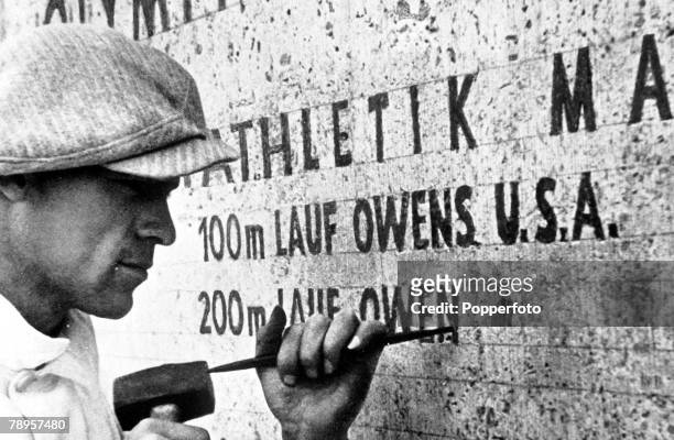 Olympic Games, Berlin, Germany, A stonemason at work records the feat of USA's Jesse Owens, winner of four gold medals in the Games
