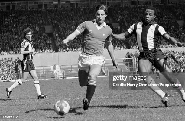 Martin Buchan of Manchester United is challenged by Cyrille Regis of West Bromwich Albion during a Football League Division One match at Old Trafford...