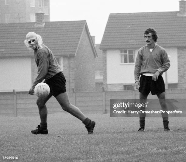 Liverpool footballer Ray Kennedy wearing a joke mask as teammate Terry McDermott looks on during a training session at Melwood in Liverpool, England,...