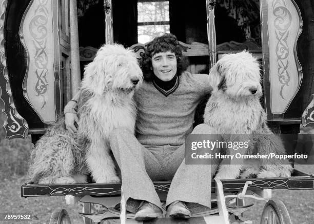 Liverpool FC and England footballer Kevin Keegan relaxes on the steps of an old romany caravan with his two Old English sheepdogs near his home near...