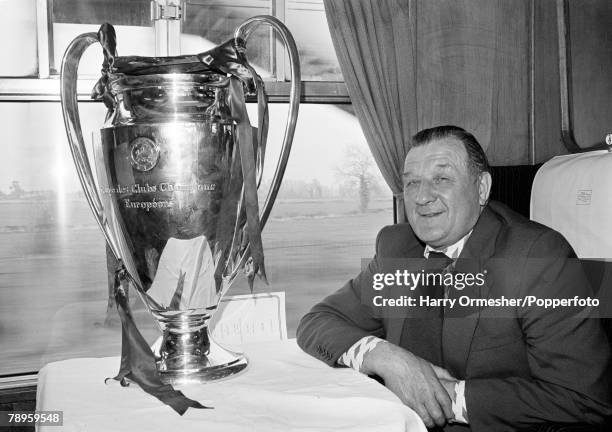 Liverpool manager Bob Paisley posing with the European Cup trophy on the train back to Liverpool the day after his team had retained the trophy with...