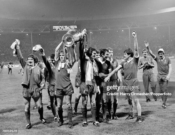 Phil Neal holds the trophy aloft with goalkeeper Ray Clemence as Liverpool celebrate after the European Cup Final between Liverpool and Club Brugge...